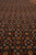 Close view of repeating herati fish motifs in orange, ivory and green on black