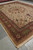 Corner perspective of palace size Persian rug with ivory selvage, fringe and layered burgundy green borders