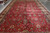 Crimson field with rosettes, saz leaves and navy outlined palmettes across this Tabriz design