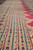 Border detail showing stacked guard stripes in camel, black and rose with small floral rosettes