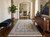 Ivory Nain rug styled in a sunlit entry hall with navy bench and walnut console