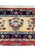 End border of a Persian Yazd rug with the Rayati signature cartouche above ivory bouquets and navy palmettes