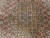 Detailed medallion close-up showing sage green outlines, navy rosettes and coral salmon herati diamonds