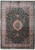 Overhead view of forest green wool and silk rug with ivory medallion and pink borders