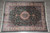 Full 9'4" x 13' green Oriental rug photographed flat on grey tile showing floral field