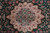 Central ivory and soft blue medallion surrounded by dense floral sprays on deep green field