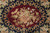 Close-up of burgundy oval center medallion filled with pink roses on navy scrollwork ground