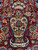 Salmon vase filled with facing birds and blossoms woven on the burgundy field axis