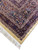 Multiple borders in salmon, navy and burgundy meeting at the corner above a clean ivory fringe