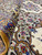 Folded corner detail revealing dense hand-knotted wool pile and brown arabesque vine scrollwork