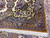 Corner fold showing camel gold main border, navy guard stripes and ivory cotton fringe