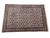 Persian Qum 11 x 17 wool rug photographed at an angle on white studio backdrop