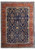 Full overhead view of navy Persian Sarouk rug with wide coral floral border