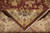 Folded corner revealing tight knotting on the back and ivory cotton fringe of the rug
