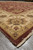Low angle of the ivory floral border and burgundy field with fringed selvage edge