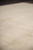 Angled close view showing low quarter inch wool pile and gentle ivory color movement