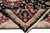 Folded corner reveals silk highlights, dense wool pile and hand-knotted back of the black rug