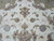 Field detail of curling gold arabesques, pink palmettes and soft green leaves on ivory wool