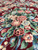 Close-up of pink roses, sage leaves and blue blossoms in the wool and silk pile