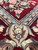 Inner border detail with salmon palmettes, sky blue ground and a leafy cream cartouche