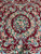 Symmetrical field pattern with flower urns, ribbon scrolls and bouquets across the wine red ground