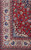 Corner detail showing ivory boteh border, light blue spandrel and dense red floral field