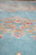 Shallow focus close-up of pink and coral blossoms scattered across the soft blue wool field
