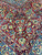 Deep red spandrel corner with ivory palmettes, green leaves and blue floral guard borders