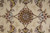 Close up of a gold, blush and burgundy rosette motif on cream wool ground