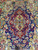 Central red lobed medallion with columns and birds set on a deep navy pictorial field