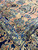Wide navy border with gold vinework meeting the peach field at a corner of the antique rug