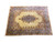 Angled studio view of the butter gold Kerman rug showing all four floral corner spandrels
