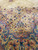 12x16 Persian Kerman rug detail where ivory spandrel meets blue main border with blossoms