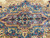 Central medallion detail in blue and rose with ivory arabesques and small cream rosettes