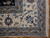 Corner detail showing camel guard stripe, ivory main border rosettes and clean cotton fringe
