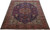 Angled floor view showing red floral border, ivory spandrels and paradise bird motifs across the wool pile