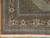 Corner detail of the burgundy border with ivory rosettes, green vines and cotton fringe