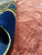 Folded corner showing dense hand-knotted wool pile depth and the even salmon field beside it