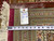 Tape measure and dealer tag confirming 8'4" x 11'8" size on hand woven Oriental rug