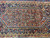 Hexagonal medallion detail showing ivory comb outline and stylized figures across the navy surrounding field