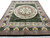 Full-length view of the black and green Savonnerie style rug photographed from the short end