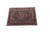 Angled floor view showing burgundy border, dark floral field and ivory fringe at both ends