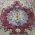 Close view of the blue star medallion with yellow center rosette on deep burgundy wool field