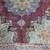 Wine red field with pendant medallion, leafy sprays and blue arabesque clusters near the main border