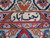 Woven weaver signature cartouche set into the ivory guard border of this Persian rug