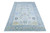 Angled view of the 12'1" x 17'4" Oushak rug showing all over pastel floral pattern
