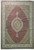 Full overhead view of pomegranate red Persian Tabriz rug with ivory scalloped medallion and border