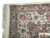 Corner close-up with ivory fringe, mauve guard stripes and burgundy palmettes in the multi band border