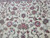 Field close-up of burgundy rosettes, pink roses and silk highlighted leaves on ivory Tabriz design rug
