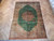 8' x 11' Persian Qum silk rug laid flat on herringbone parquet floor, full view